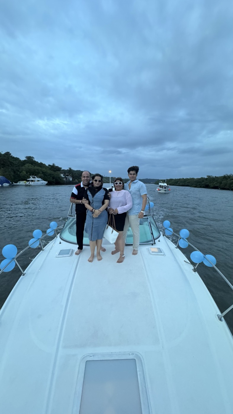 Family celebrating a birthday on a yacht bow in Goa, balloons along the railing