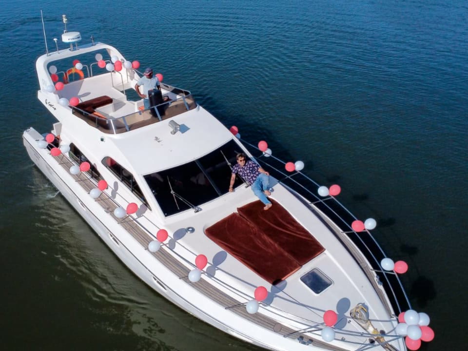 Ambassador yacht dressed in red and white balloons for a birthday charter on the river in Goa
