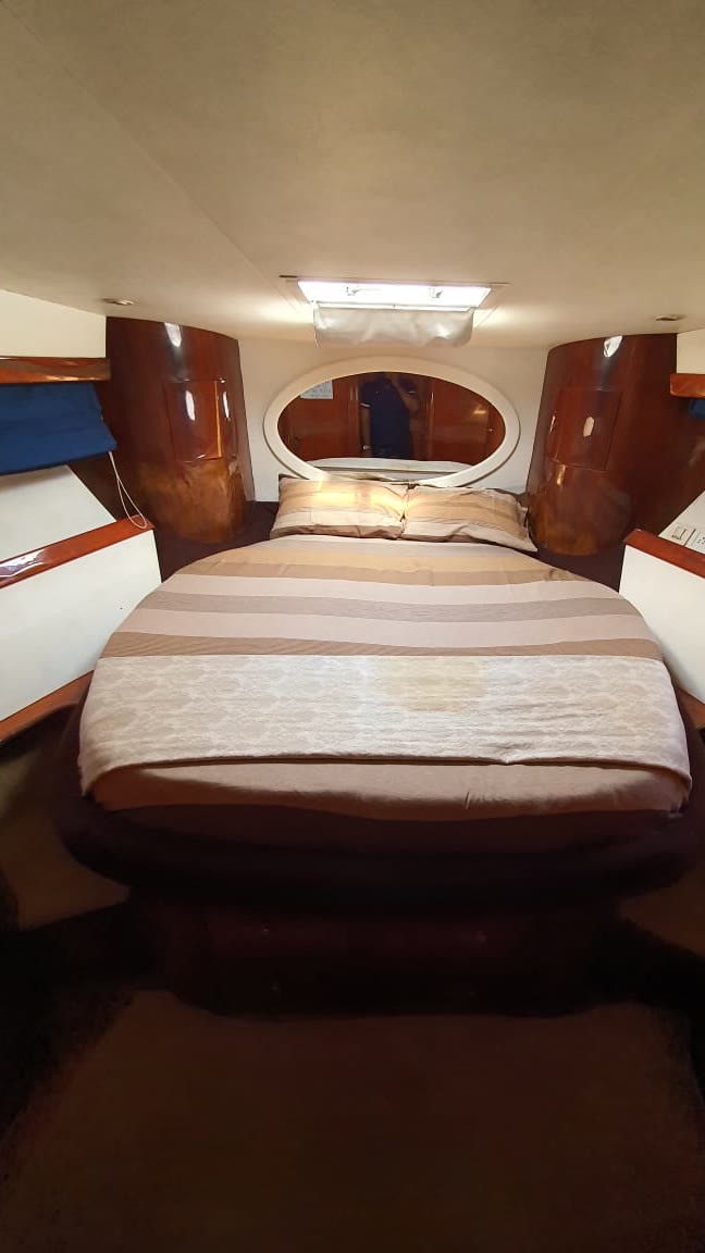Ensuite double-bed suite with wood panelling below deck on the Ambassador yacht, Goa