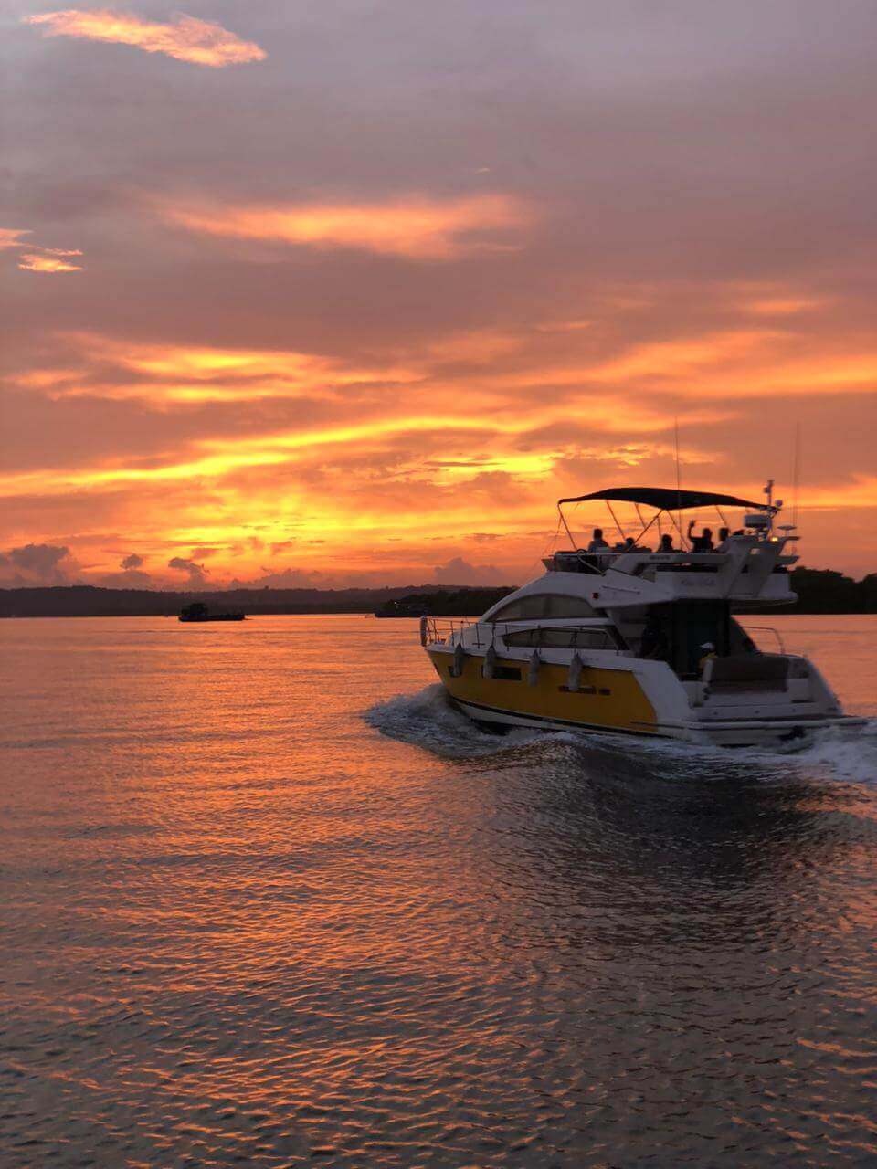 Ciao Bella, the yellow yacht, at sunset on the Mandovi River, Goa