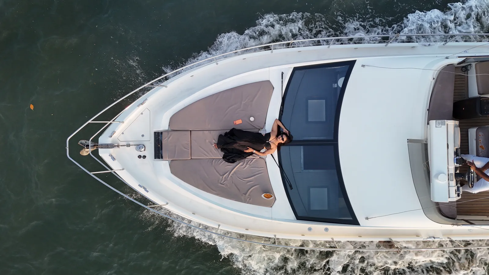 Aerial drone shot of the Ciao Bella yellow yacht cruising the Mandovi River, Goa