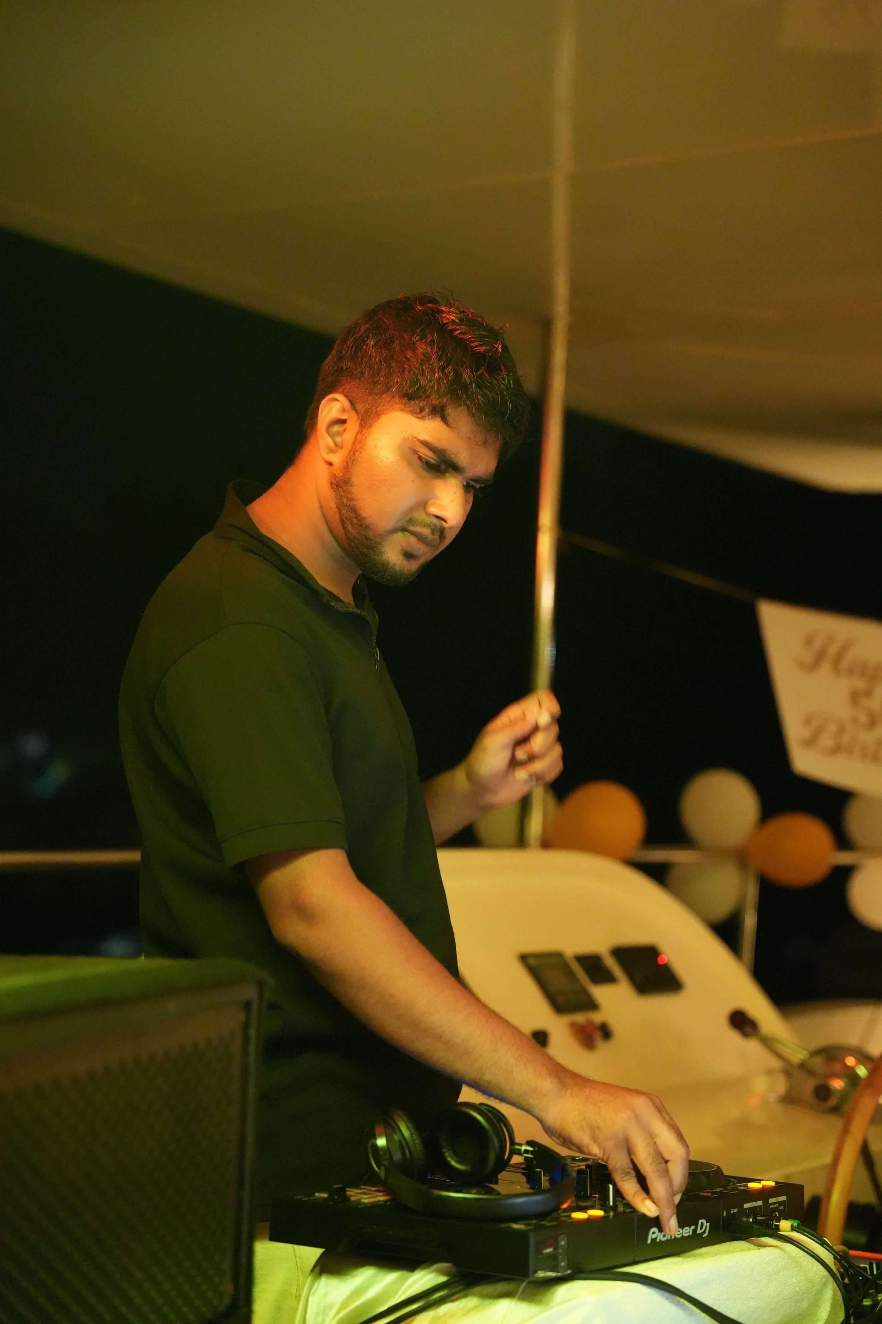 The DJ working the decks on Leo Mar's top deck at night
