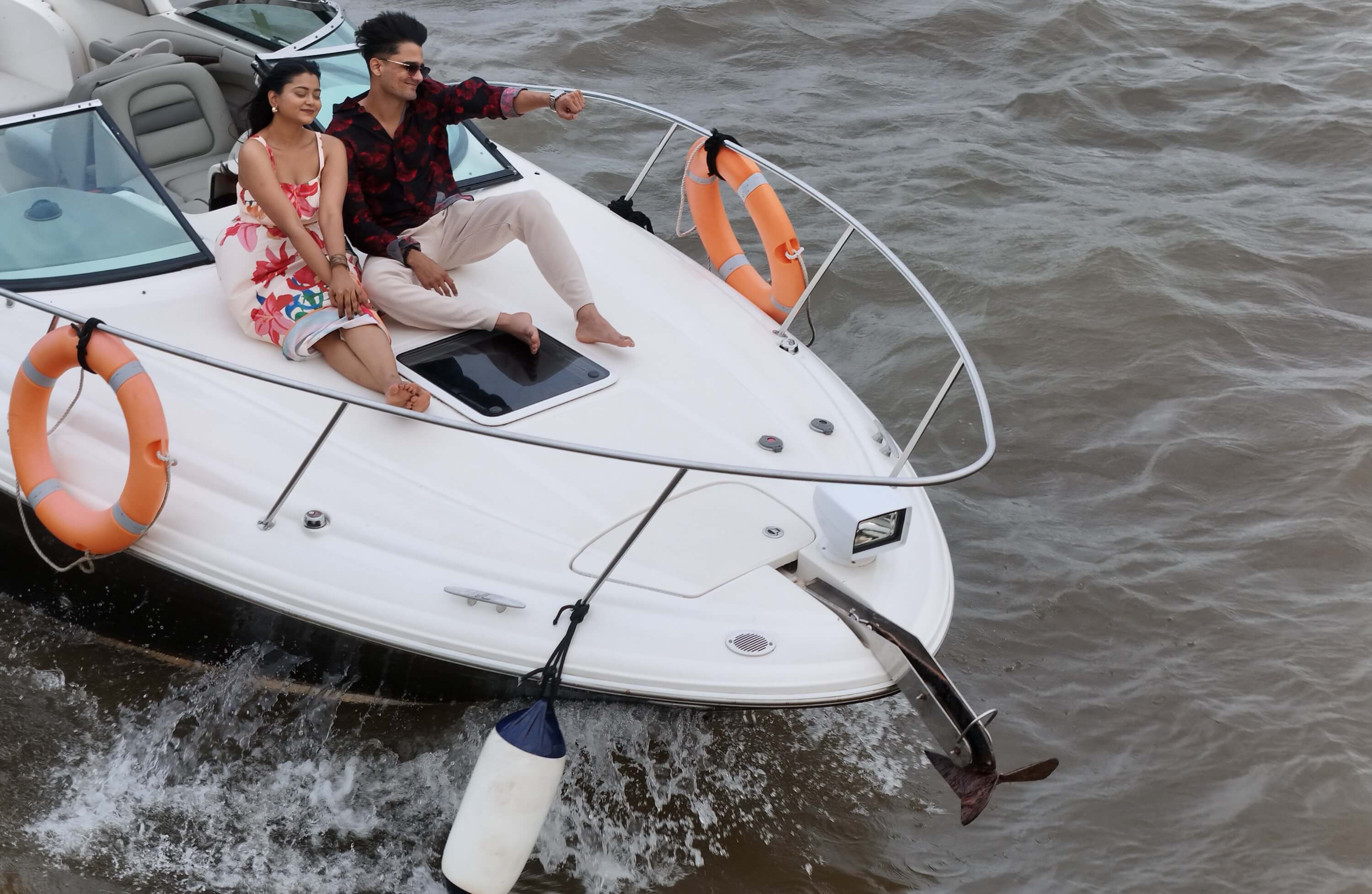 A couple seated together on the bow of the Solstice yacht, cruising the Mandovi River in Goa